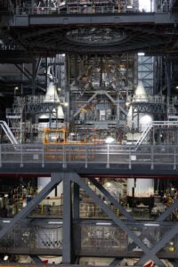 Two white SLS solid rocket boosters with nose cones standing inside the Vehicle Assembly Building