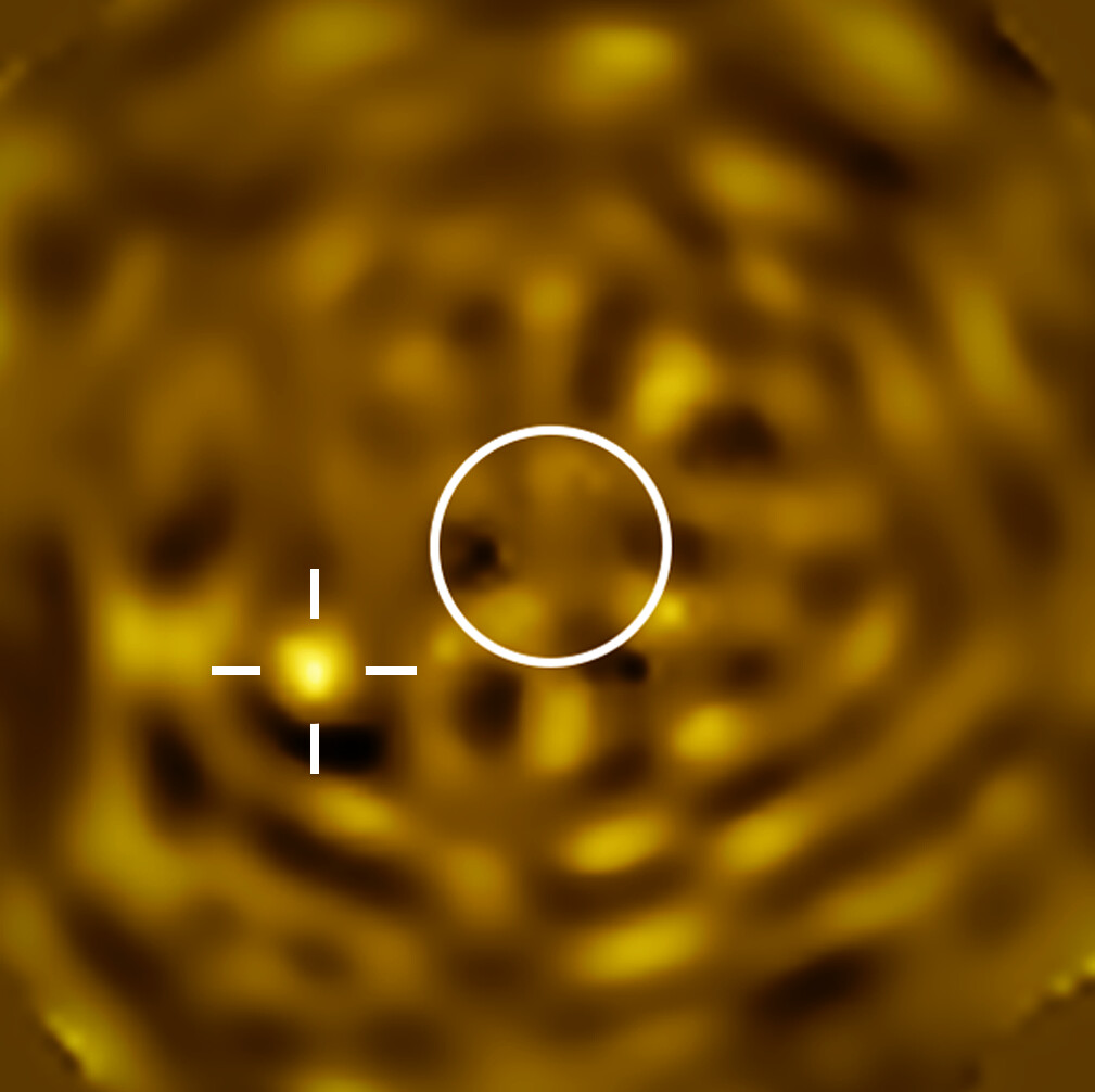 SPHERE image with a circle marking the size of Betelgeuse and a crosshair on a faint nearby source