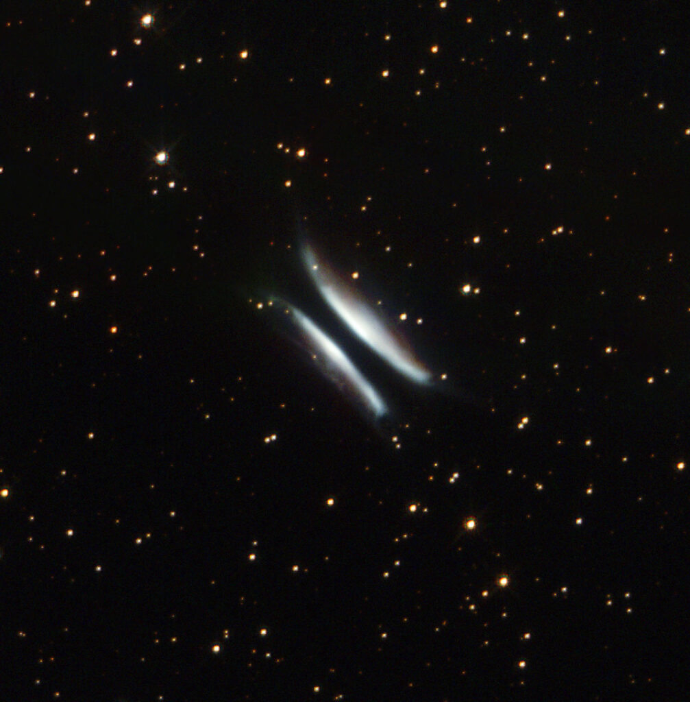 Hubble image of Gomez's Hamburger: two glowing lobes separated by a dark horizontal band of dust