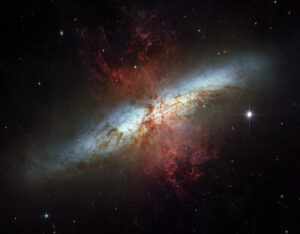 Hubble image of the Cigar Galaxy M82 with red plumes of hydrogen streaming from its core