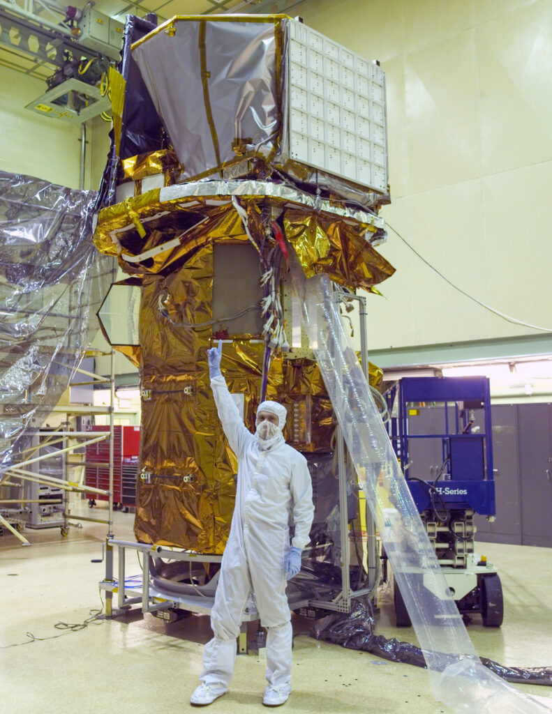 Neil Gehrels points to the instruments on top of the completed Swift spacecraft in a NASA Goddard clean room